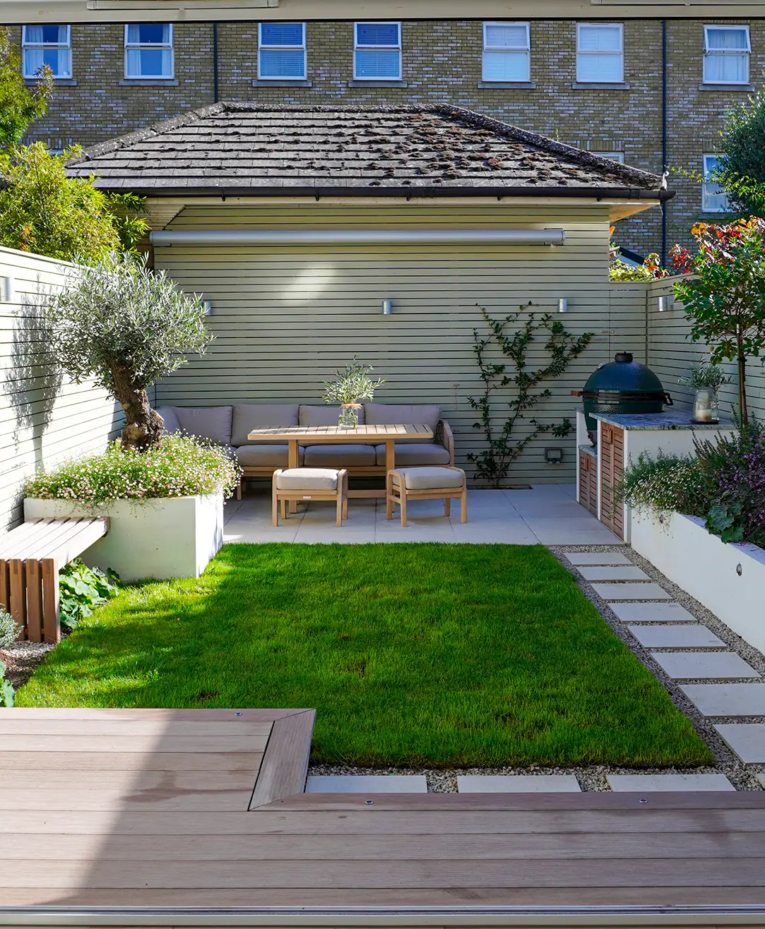 Compact residential garden with lawn and seating area.