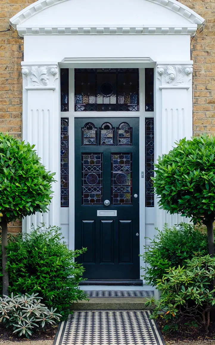 Formal front garden planting framing a traditional townhouse entrance.